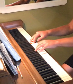 Hands playing piano during a music lesson